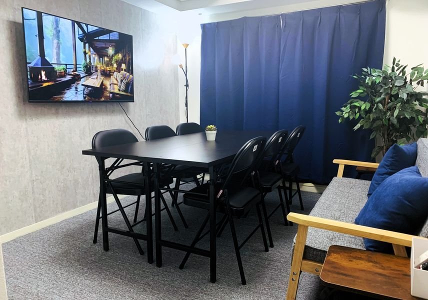 室内全景。6人掛けのテーブルと50型モニター